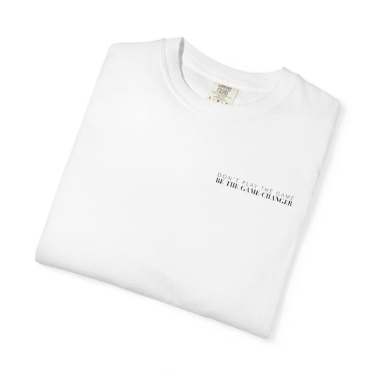 A folded short sleeve white t-shirt with black letters that say don't play the game be the game-changer across the left chest