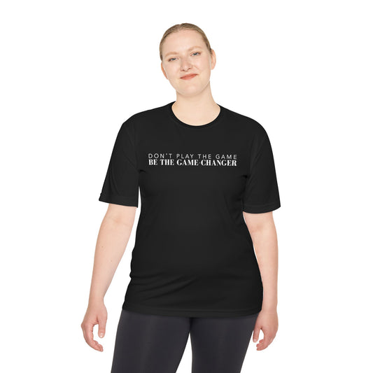 A smiling woman with blonde hair and blue eyes wearing black leggings and a short sleeve black t-shirt with white letters that say don't play the game be the game-changer across the chest