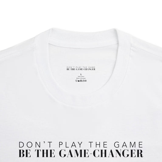 A close up of a short sleeve white t-shirt with black letters that say don't play the game be the game-changer that displays the inner label of the shirt with the brand name, size, where the shirt is made, what it is made of, and the laundry instructions