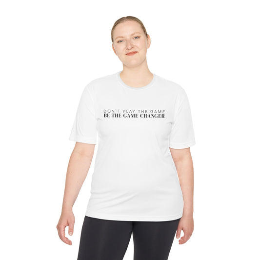 A smiling woman with blonde hair and blue eyes wearing black leggings and a short sleeve white t-shirt with black letters that say don't play the game be the game-changer across the chest