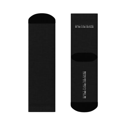 black socks with black accents on the toes and heel and black text on the back and bottom of the sock that says don't play the game be the game-changer