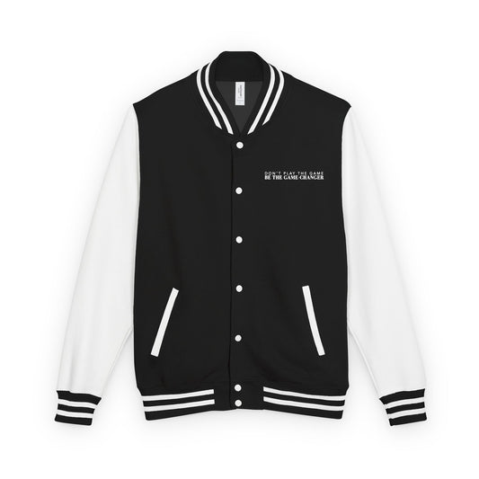 A varsity jacket with white leather sleeves with black and white striped accents, a black fabric body with black and white striped accents on the collar and bottom of the jacket and white pockets and buttons with don't play the game be the game-changer written in white text across the left chest 