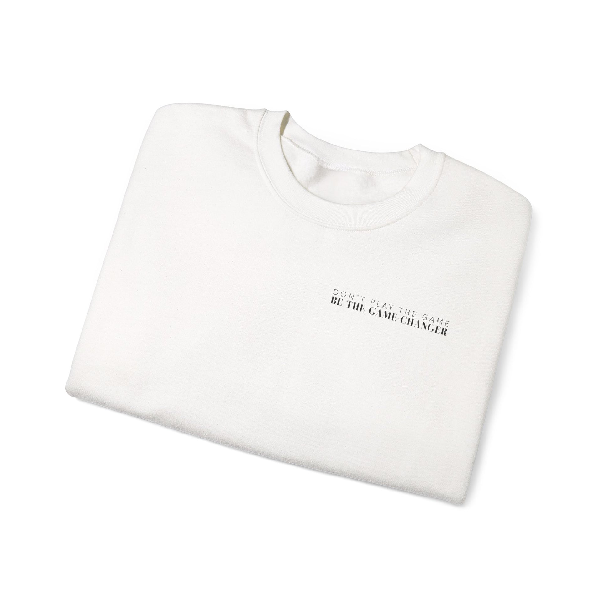 A folded cozy white crewneck sweater with black letters that say don't play the game be the game-changer over the left chest 
