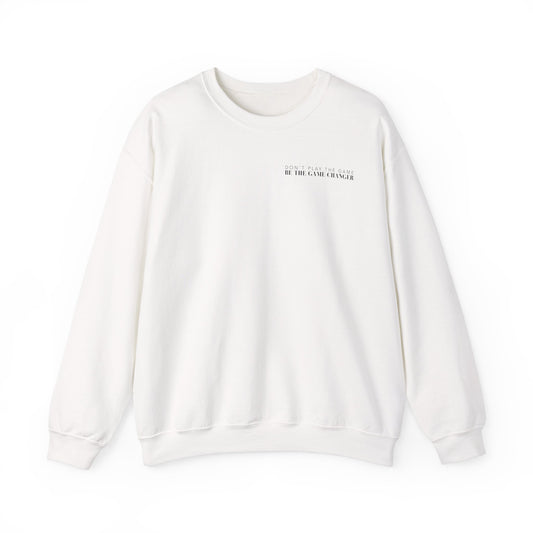 A cozy white crewneck sweater with black letters that say don't play the game be the game-changer over the left chest 