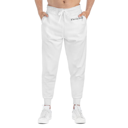 A front view of a man from the belly button down wearing white sneakers and white joggers with a white draw string and don't play the game be the game-changer written in small black text across the left hip below the waistband