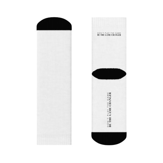 white socks with black accents on the toes and heel and black text on the back and bottom of the sock that says don't play the game be the game-changer