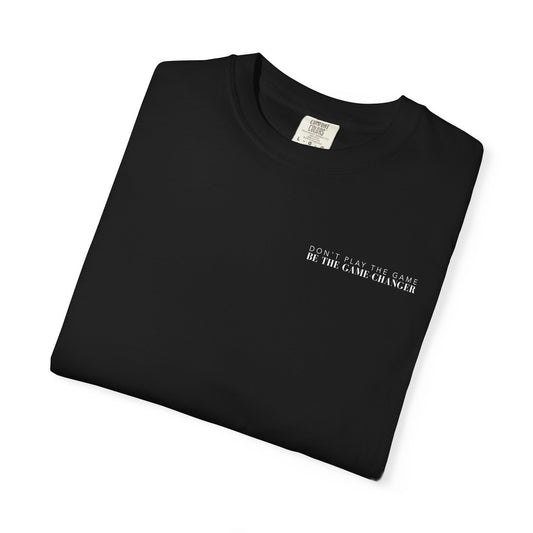 A folded short sleeve black t-shirt with white letters that say don't play the game be the game-changer across the left chest
