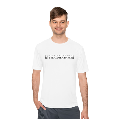 A smiling man with brown hair and hazel eyes wearing gray work out shorts and a short sleeve white t-shirt with black letters that say don't play the game be the game-changer across the chest